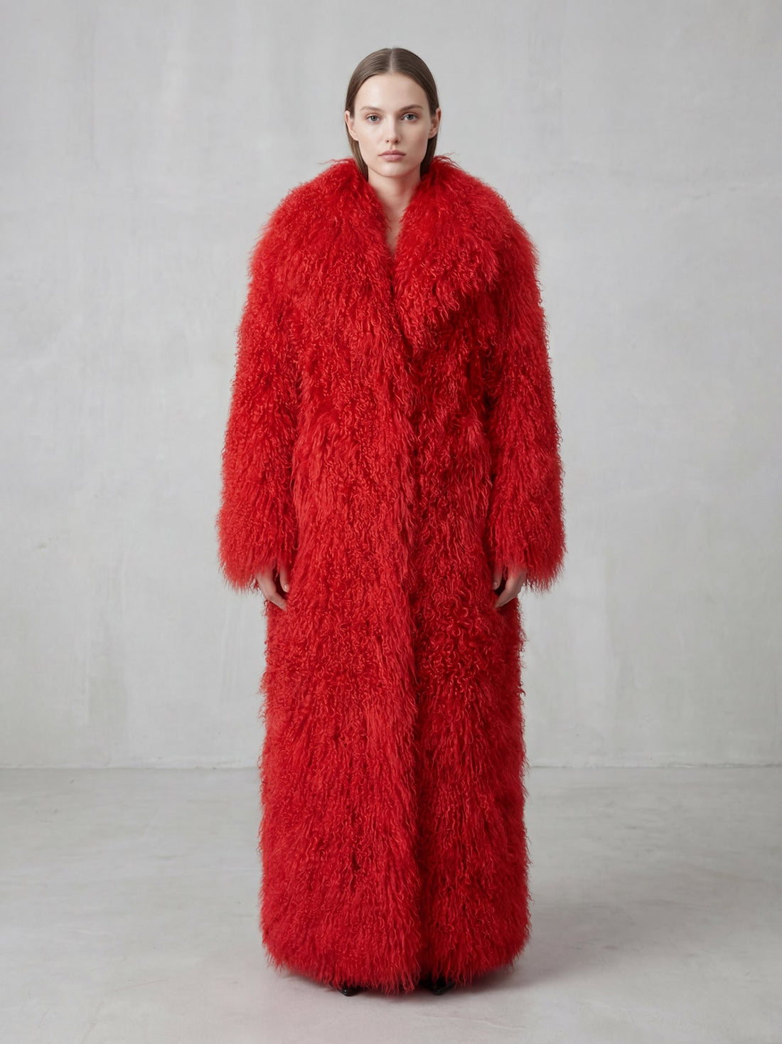 Model wearing a long red Mongolian fur coat with dense curly shearling texture – UK women’s winter outerwear