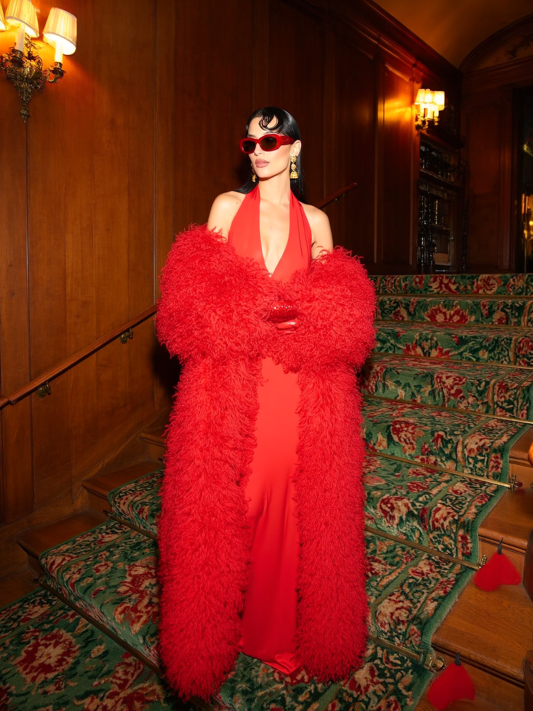 Model wearing a long red Mongolian fur coat with dense curly shearling texture – UK women’s winter outerwear