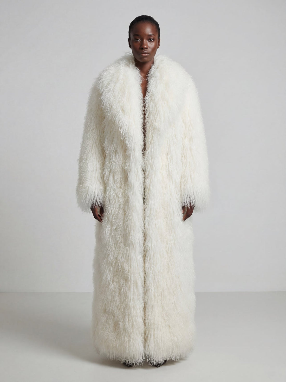 Model wearing a long white Mongolian fur coat with dense curly shearling texture – UK women’s winter outerwear