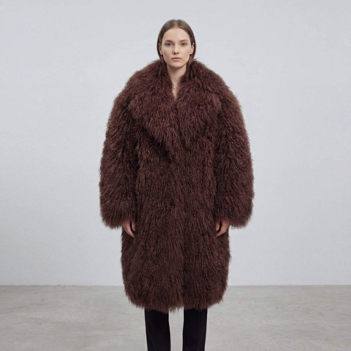 Model wearing a long brown Mongolian fur coat with dense curly shearling texture – UK women’s winter outerwear