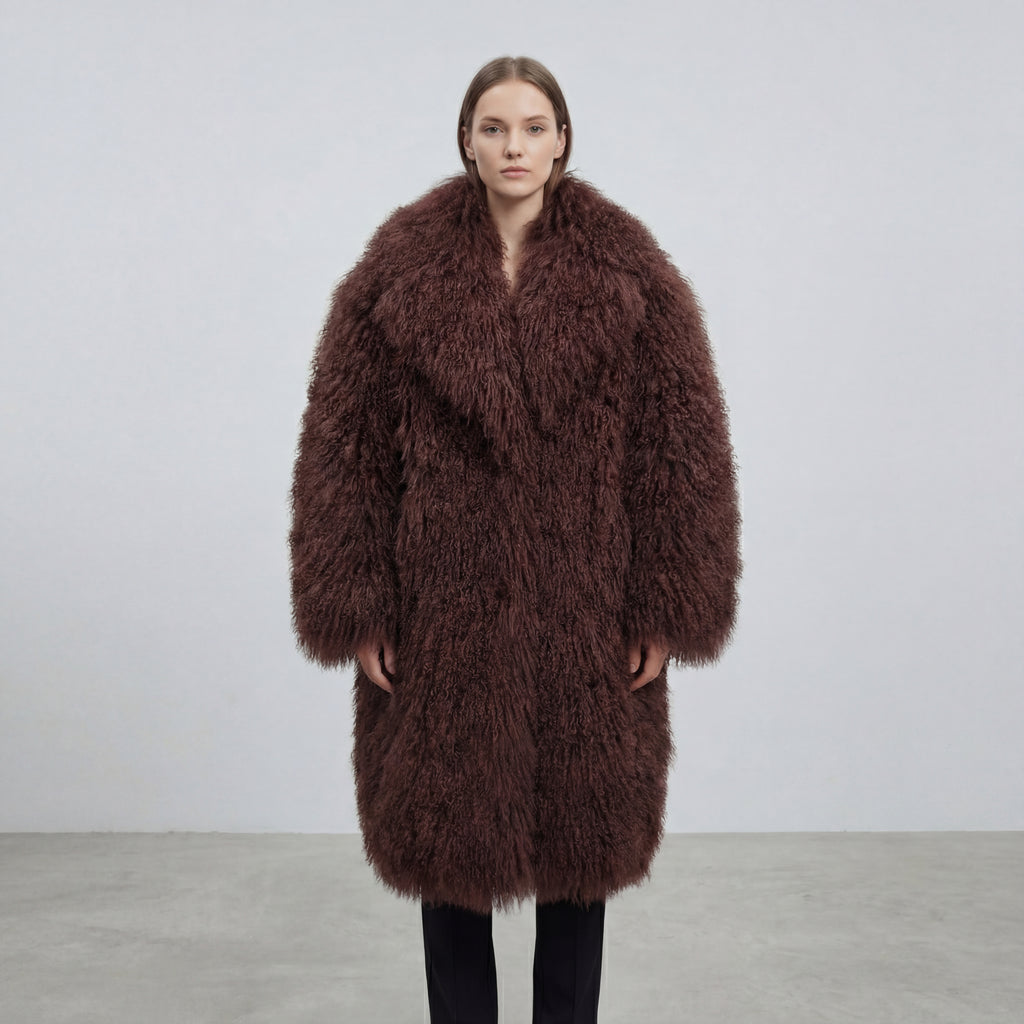 Model wearing a long brown Mongolian fur coat with dense curly shearling texture – UK women’s winter outerwear