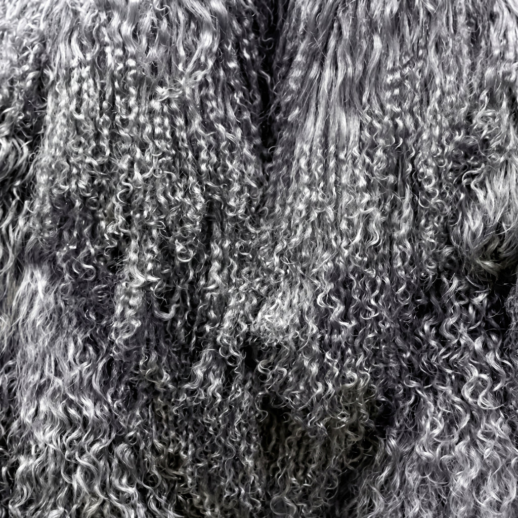 Close-up of grey Mongolian fur coat showing dense curly shearling texture – UK women’s winter outerwear