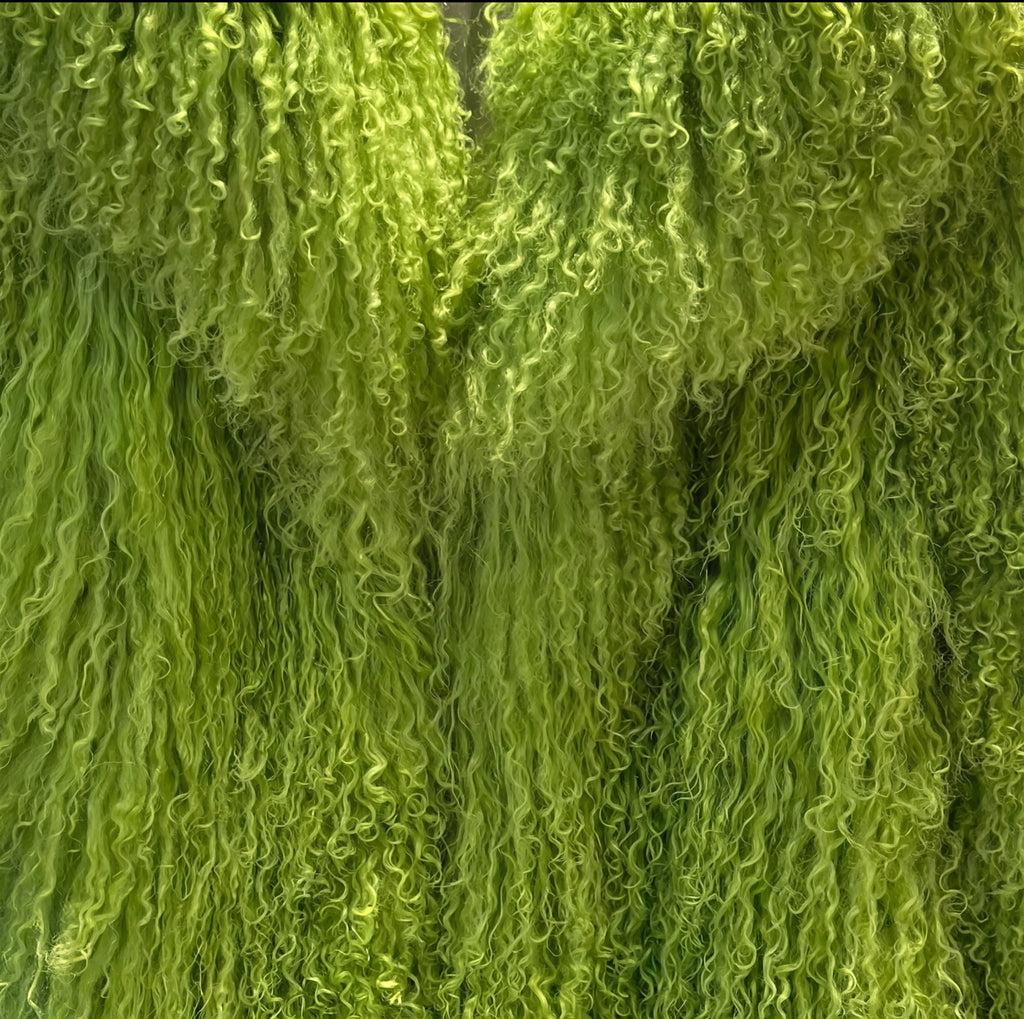 Close-up of lime green Mongolian fur coat showing dense curly shearling texture – UK women’s winter outerwear