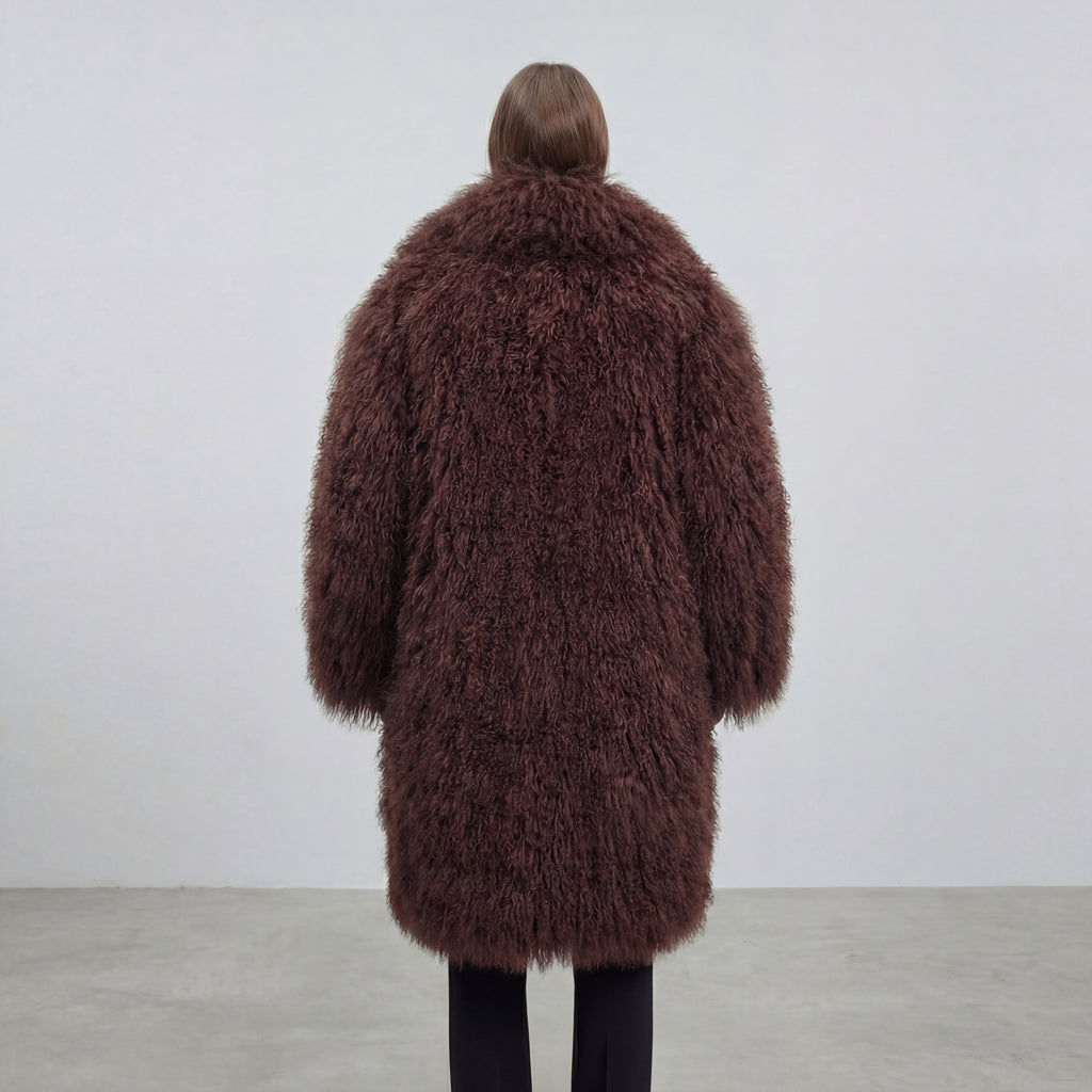 Model wearing a long brown Mongolian fur coat with dense curly shearling texture – UK women’s winter outerwear
