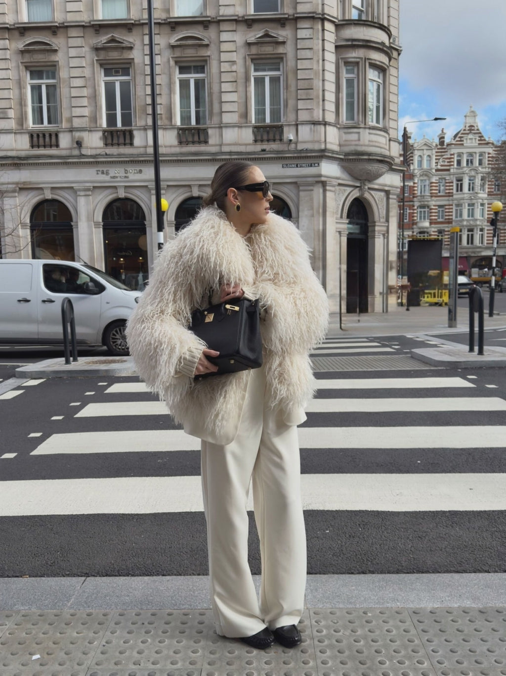 Close-up of white Mongolian fur coat showing dense curly shearling texture – UK women’s winter outerwear